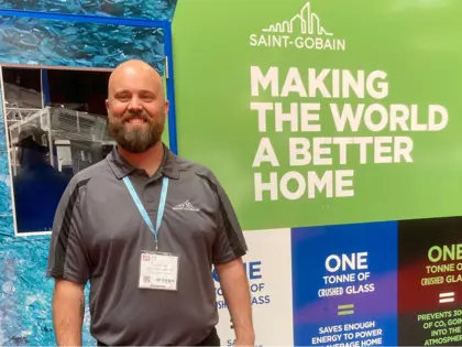 Man standing in front of display outlining Saint-Gobain's GlassForever programme